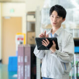 工場の生産ラインでアラーム対応する作業員とデータ分析による製造業のカイゼン改善イメージ